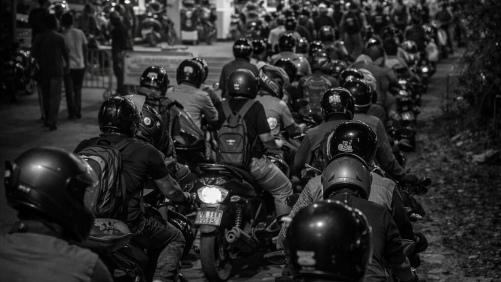 Black and white image of people waiting in long line with bikes at petrol station for fuel (representative image).